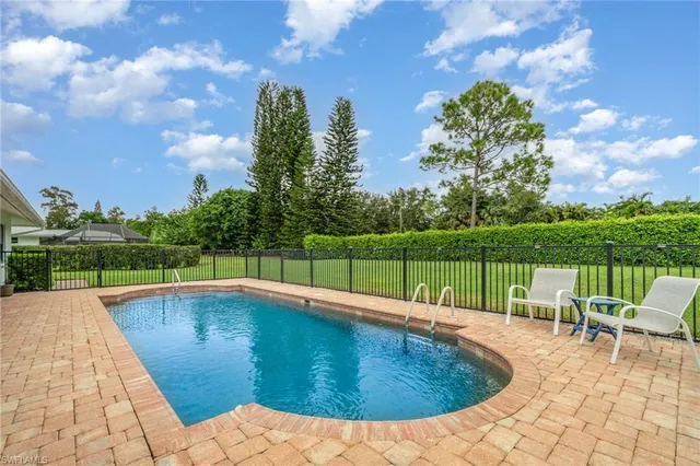 a swimming pool with outdoor seating and garden