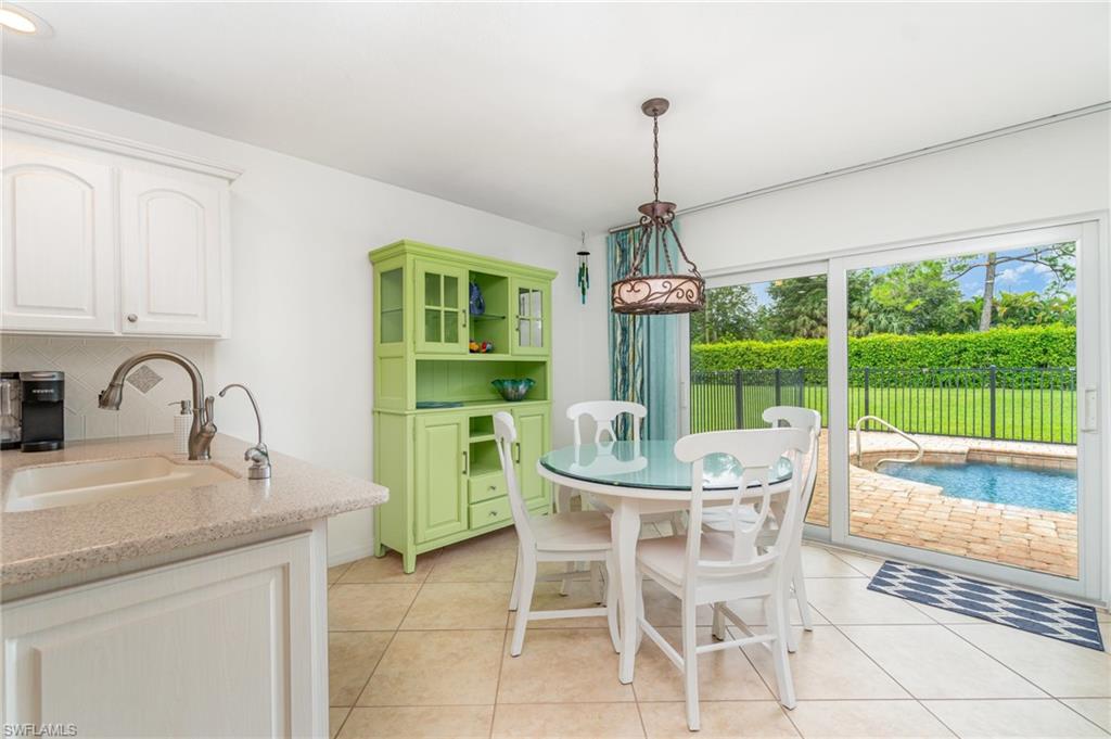 1933 Countess Court Naples, FL 34110 - Photo 8 of 25 a dining room with furniture a chandelier and a rug
