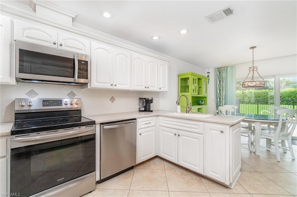 1933 Countess Court Naples, FL 34110 - Photo 10 of 25 a kitchen with a stove and a microwave