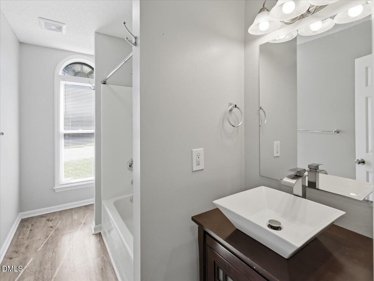 5 Jenee Lane Durham, NC 27703 - Photo 45 of 60 a bathroom with a sink a mirror and a window