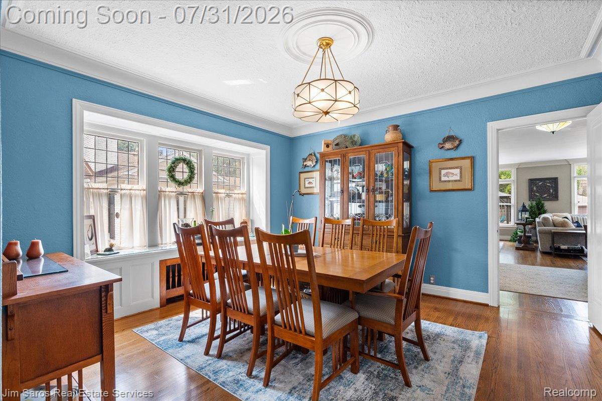 637 Washington Road Grosse Pointe, MI 48230 - Photo 14 of 40 Dining area featuring wood-finish flooring, a decorative ceiling medallion, and a bay window with multiple panes