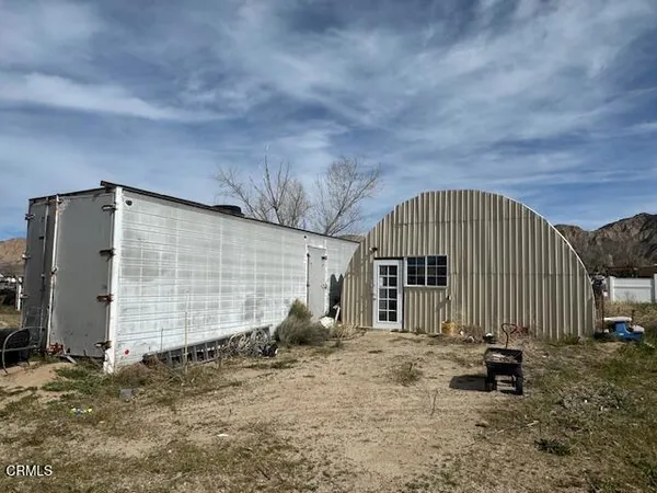 a view of a garden with a barn in the background