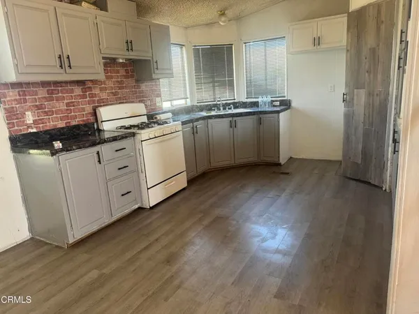 a view of a kitchen with a sink and cabinet with granite floor