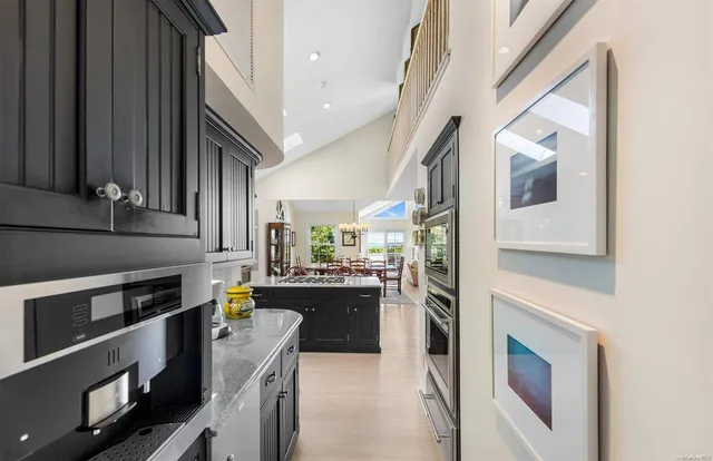 a kitchen with stainless steel appliances kitchen island granite countertop a refrigerator a stove and a sink with cabinets