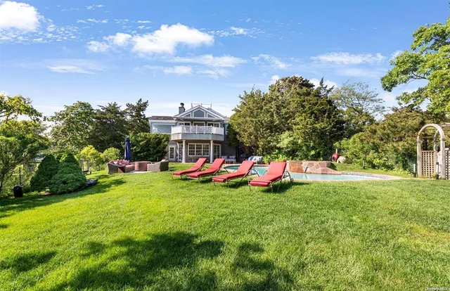 a view of yard with swimming pool and trees in the background