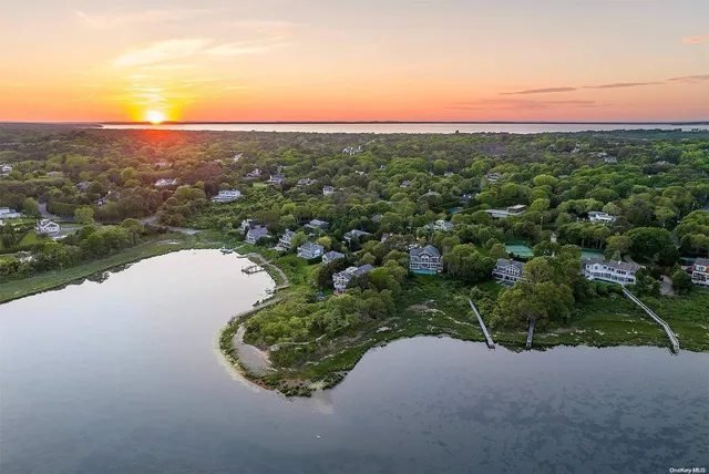 an aerial view of a houses with a yard and lake view