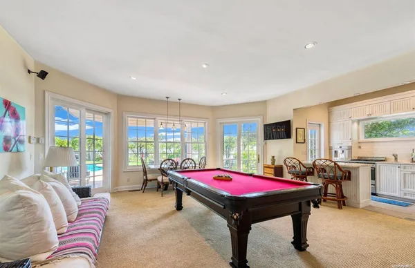 a room with furniture pool table and windows