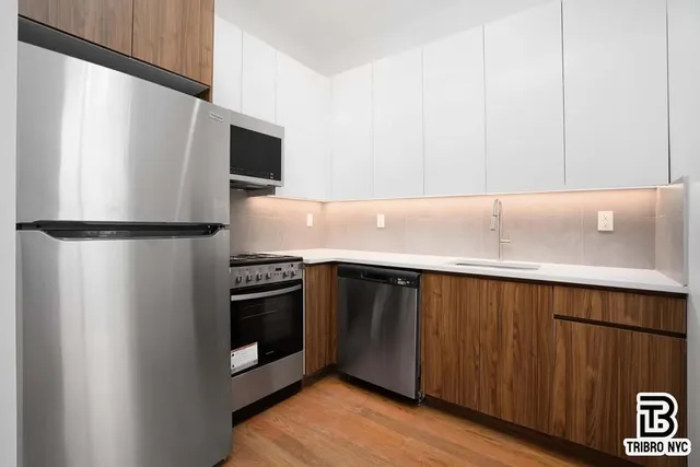 a kitchen with stainless steel appliances a refrigerator and a microwave