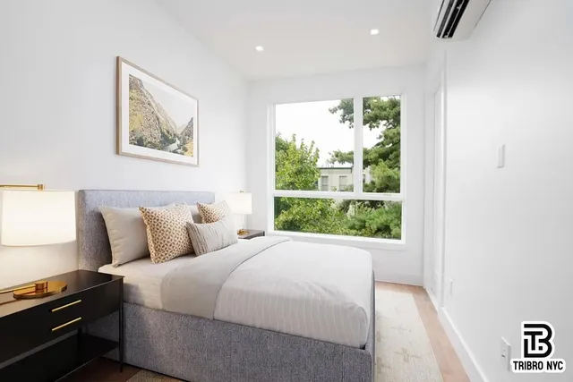 a bed room with a bed and a large window