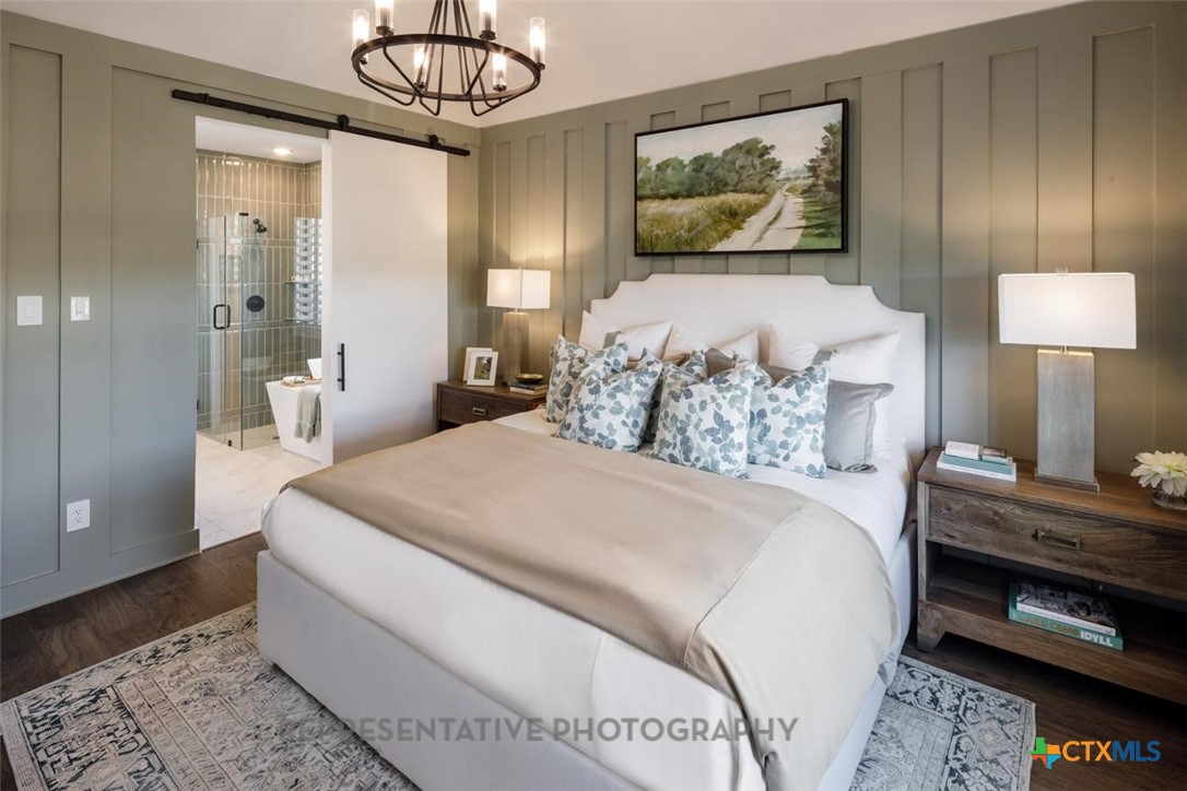 9212 Boathouse Drive Austin, TX 78744 - Photo 18 of 40 a bedroom with a bed and a chandelier