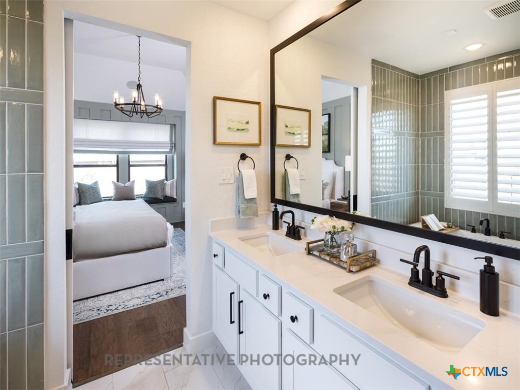 9212 Boathouse Drive Austin, TX 78744 - Photo 26 of 40 a bathroom with double vanity sink a mirror a vanity and window