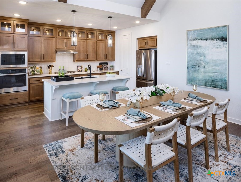 9212 Boathouse Drive Austin, TX 78744 - Photo 30 of 40 a kitchen with a dining table chairs and refrigerator