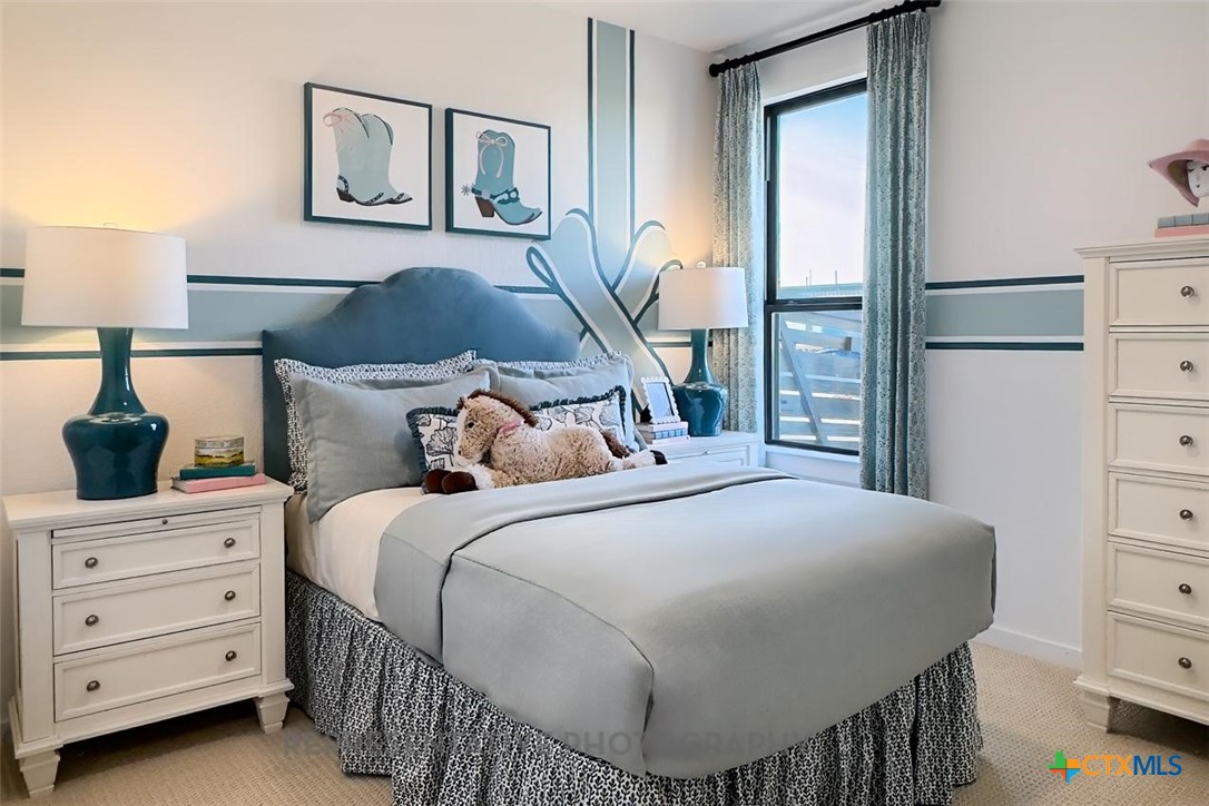 9212 Boathouse Drive Austin, TX 78744 - Photo 37 of 40 a bedroom with a bed a mirror and lamp