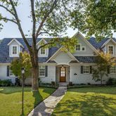 a front view of a house with a garden and trees