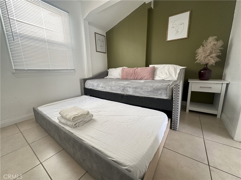 9723 Belmont Street, Unit 1/2 Bellflower, CA 90706 - Photo 5 of 7 a bedroom with a bed and a table