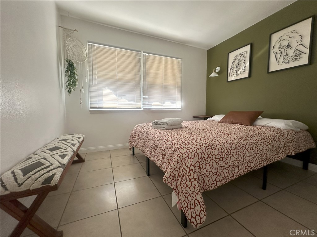 9723 Belmont Street, Unit 1/2 Bellflower, CA 90706 - Photo 6 of 7 a bedroom with a bed and a window
