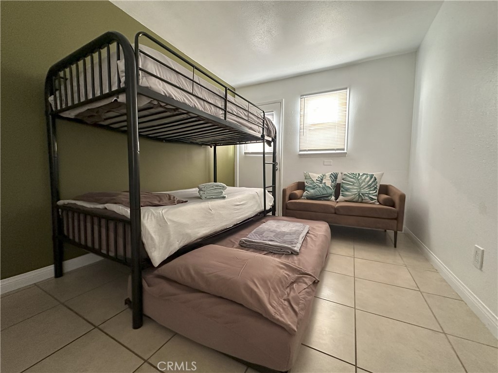 9723 Belmont Street, Unit 1/2 Bellflower, CA 90706 - Photo 7 of 7 a bedroom with furniture and a window