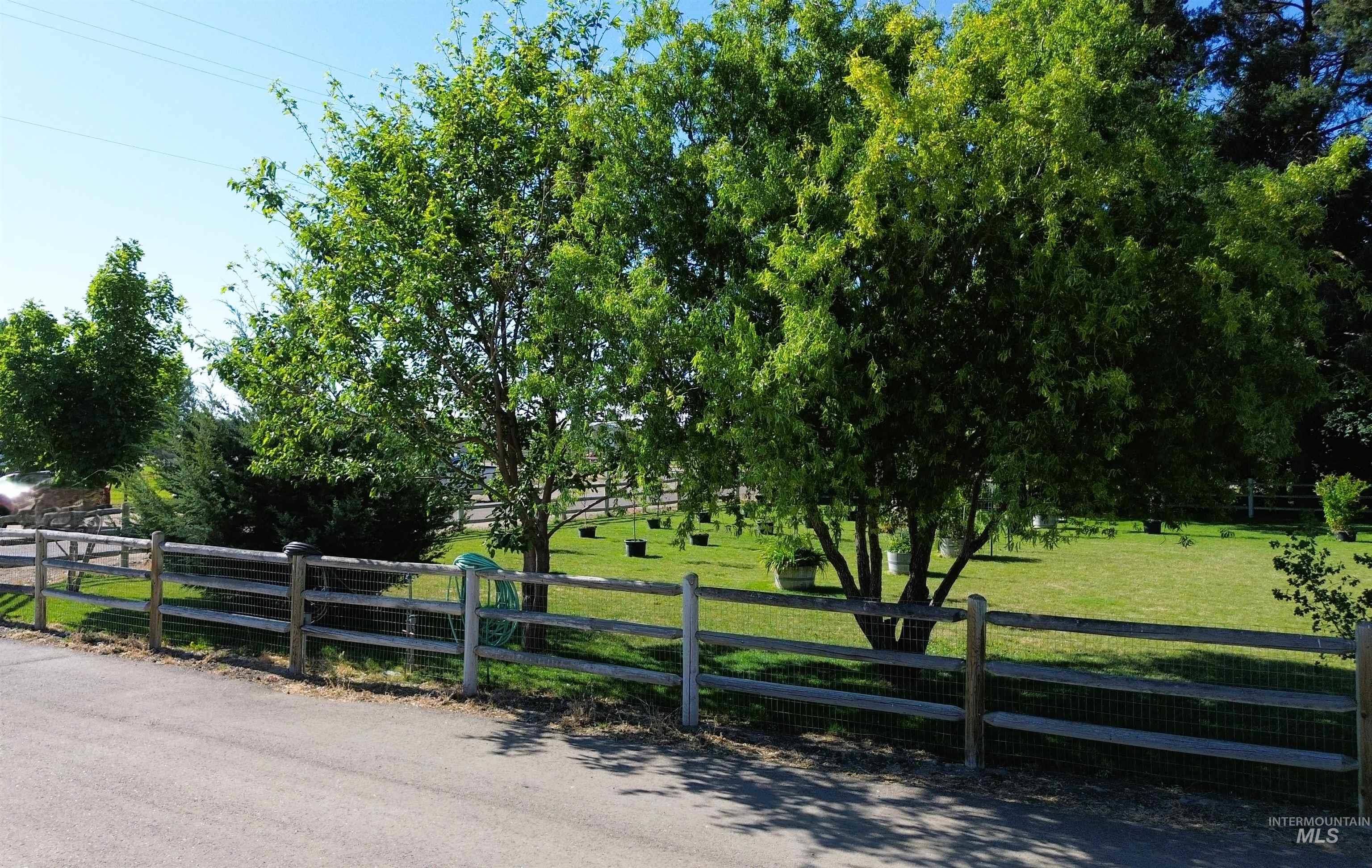 16985 Garnet Road Wilder, ID 83676 - Photo 2 of 39 Expansive grass lawn bordered by a split-rail fence with wire mesh