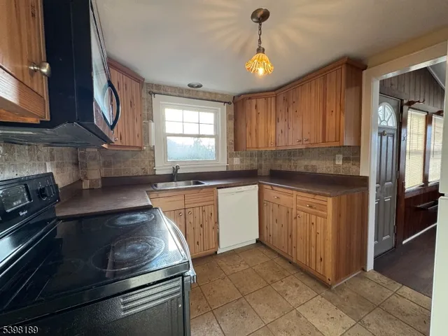 a kitchen with granite countertop a stove sink and cabinets