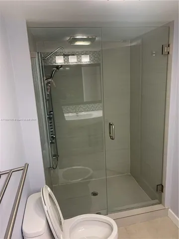 a bathroom with a shower a toilet and sink