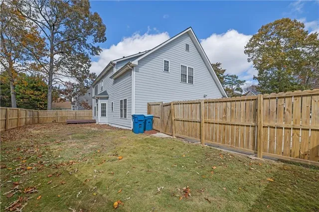 a view of backyard of house with wooden fence