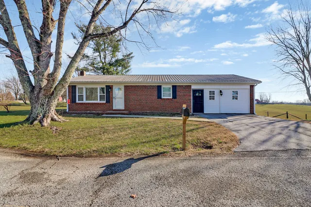 a view of a house with a yard covered in snow