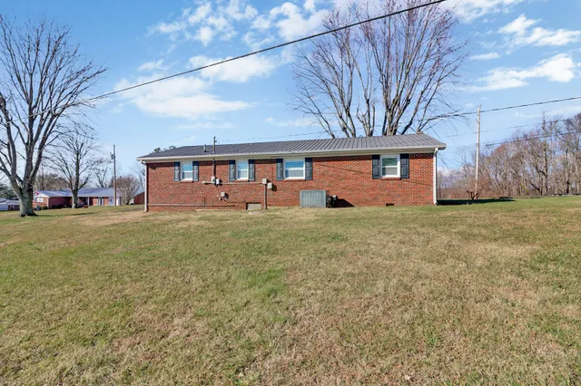 a front view of house with yard and trees around