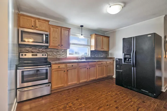 a kitchen with granite countertop a refrigerator stove and microwave