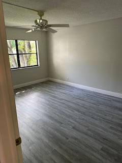 303 Racquet Club Road, Unit 201 Weston, FL 33326 - Photo 9 of 20 wooden floor in an empty room with a window