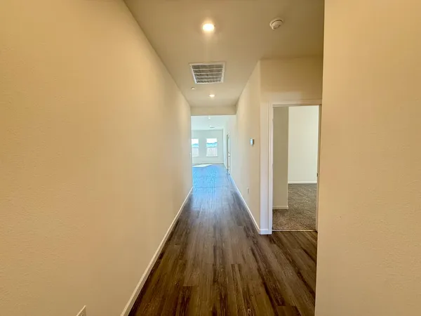 a view of a hallway with wooden floor
