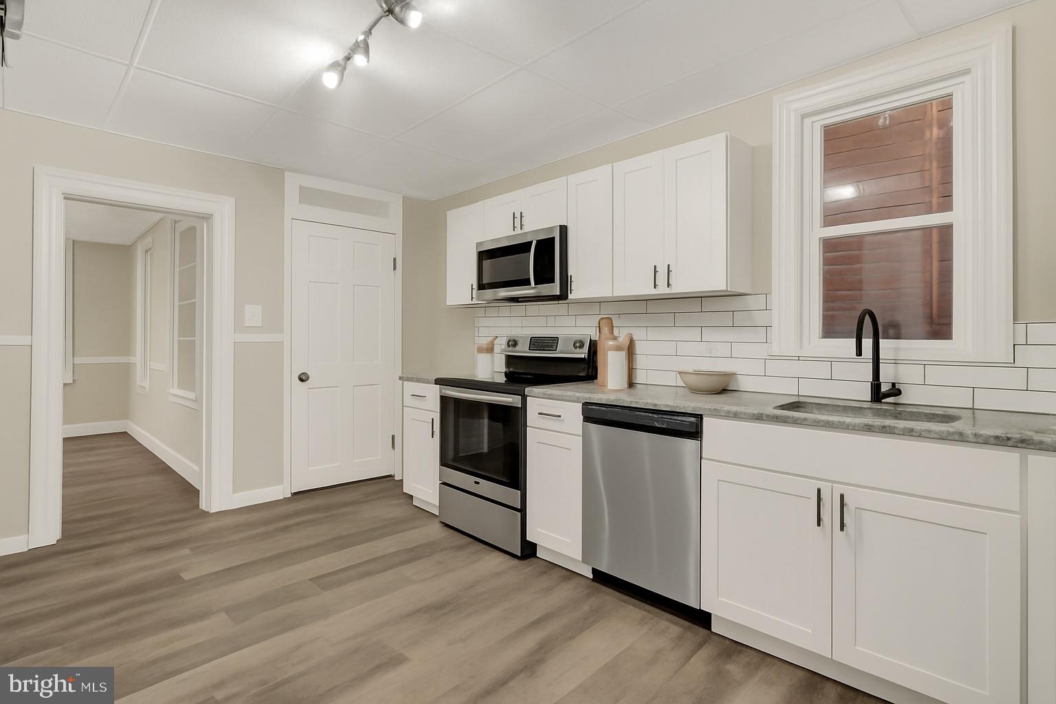 551 York Street Hanover, PA 17331 - Photo 7 of 24 a kitchen with granite countertop white cabinets and white appliances