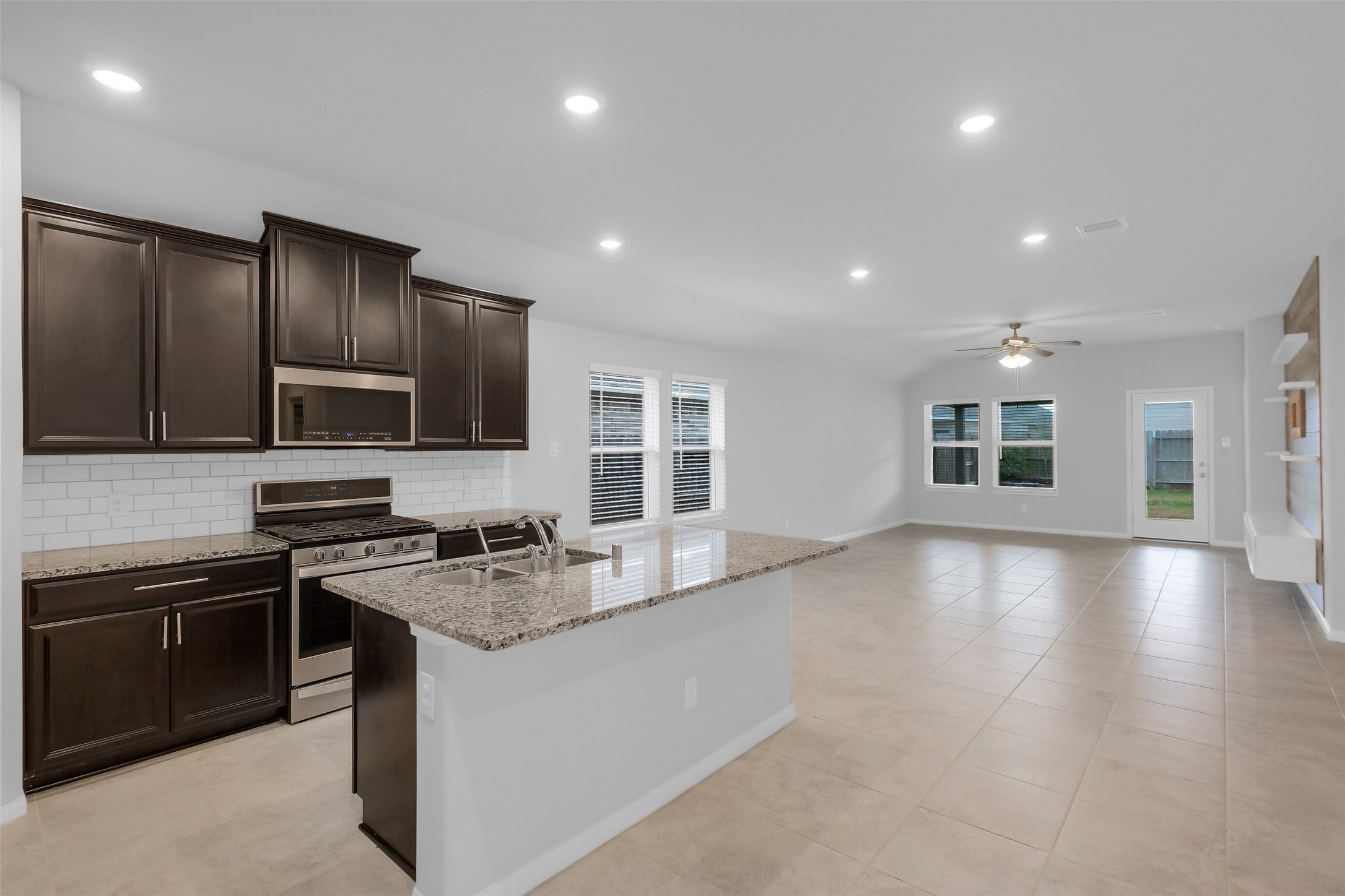 2442 Goddard Grn Drive Rosharon, TX 77583 - Photo 4 of 34 a kitchen with stainless steel appliances granite countertop a stove a sink and a microwave
