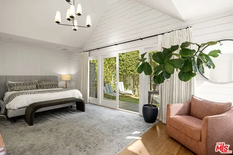 a bedroom with furniture and a large window