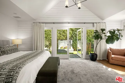 a spacious bedroom with a balcony a bed and a couch