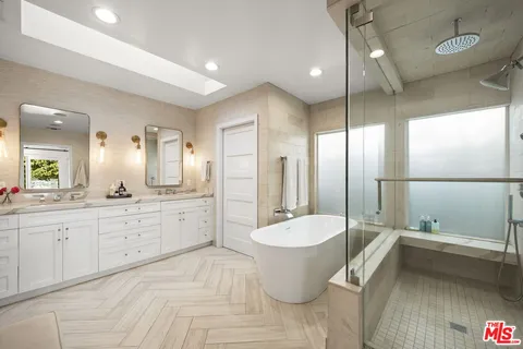a large bathroom with a double vanity sink toilet a large mirror and shower