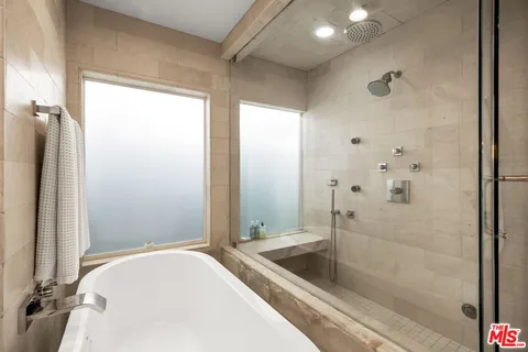 a bathroom with a granite countertop sink and a bathtub
