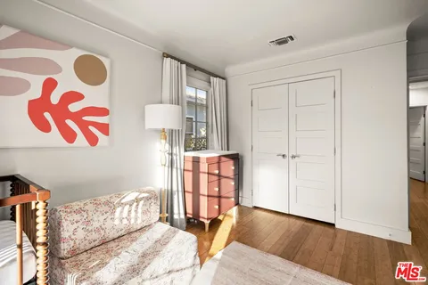 a bed room with a bed and a painting on the wall