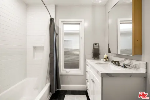 a bathroom with a bathtub a sink a vanity and a shower
