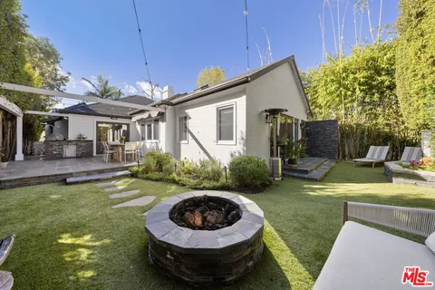 a view of a house with backyard and sitting area