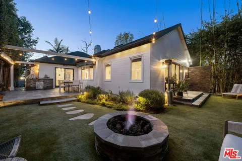 a view of a house with backyard and sitting area