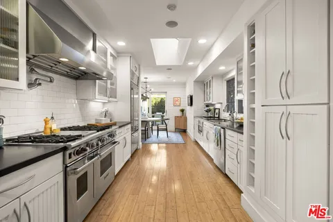 a kitchen with stainless steel appliances a stove a sink and a refrigerator