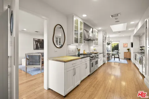 a large kitchen with stainless steel appliances granite countertop a lot of counter space and wooden floors