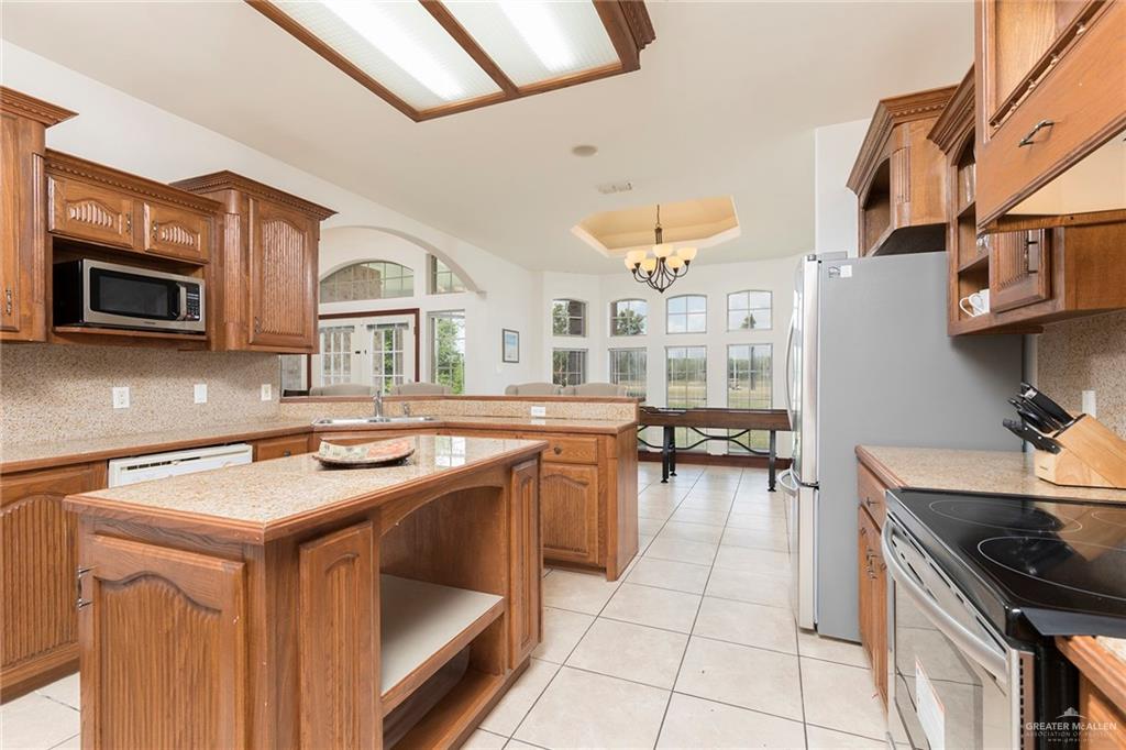 1213 Rhett Drive Pharr, TX 78577 - Photo 6 of 19 Gourmet kitchen with granite countertops, custom cabinetry, center island, and breakfast bar.
