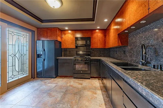 a kitchen with stainless steel appliances granite countertop a refrigerator and a sink