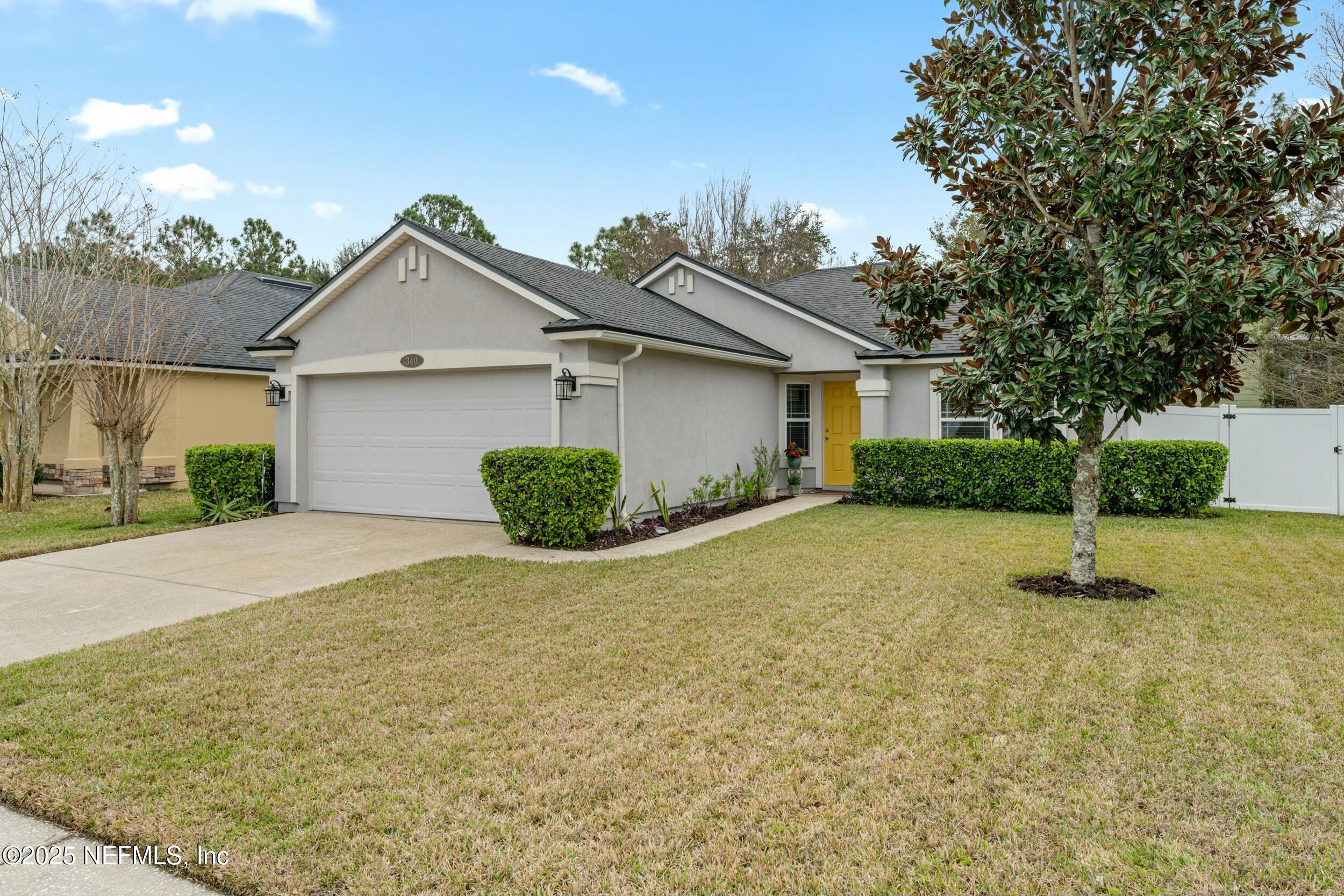 340 Sunshine Drive St. Augustine, FL 32086 - Photo 11 of 44 a front view of a house with a yard and garage