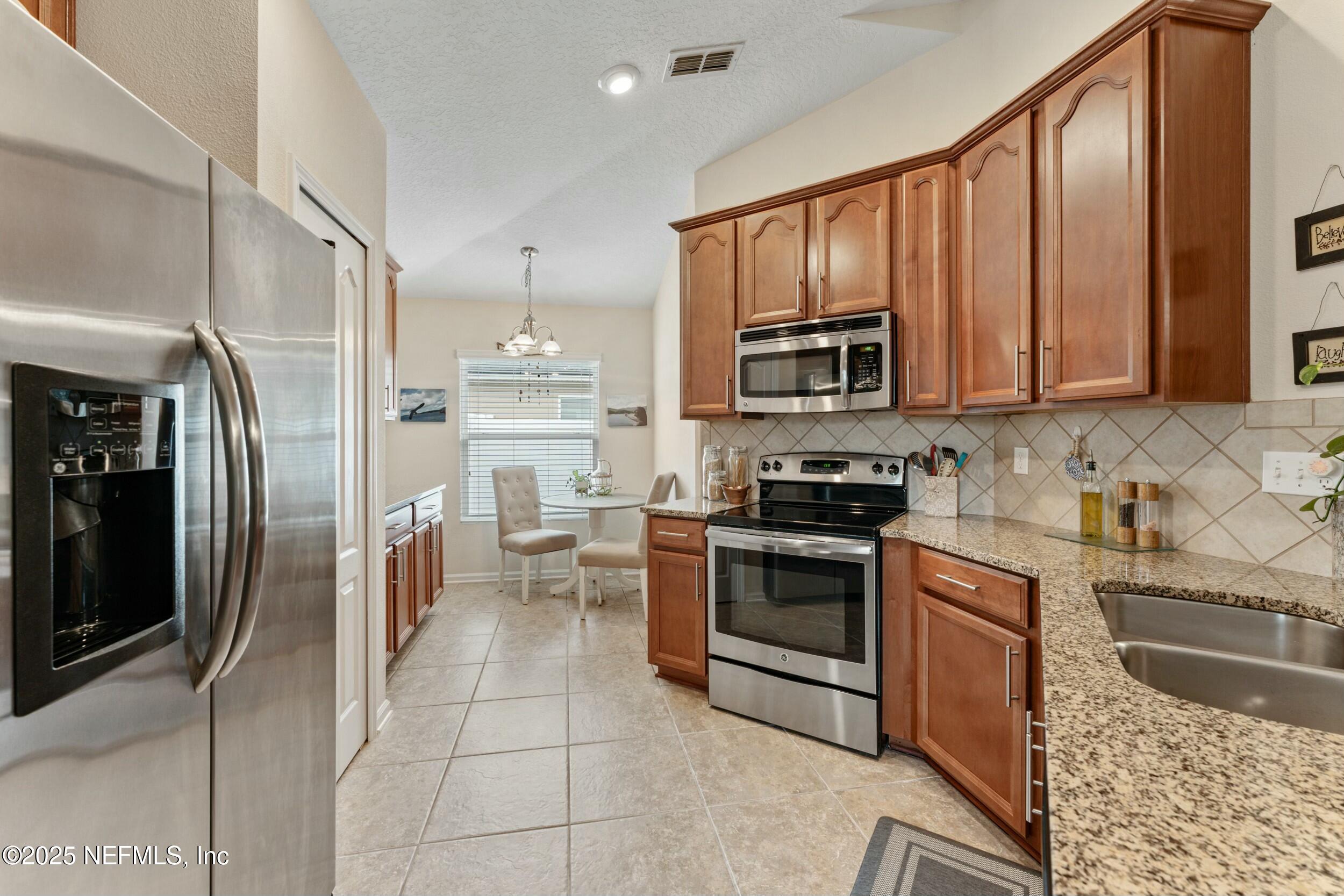 340 Sunshine Drive St. Augustine, FL 32086 - Photo 21 of 44 a kitchen with stainless steel appliances granite countertop a refrigerator stove and sink