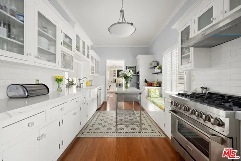 a kitchen with stainless steel appliances granite countertop a stove and a wooden floors