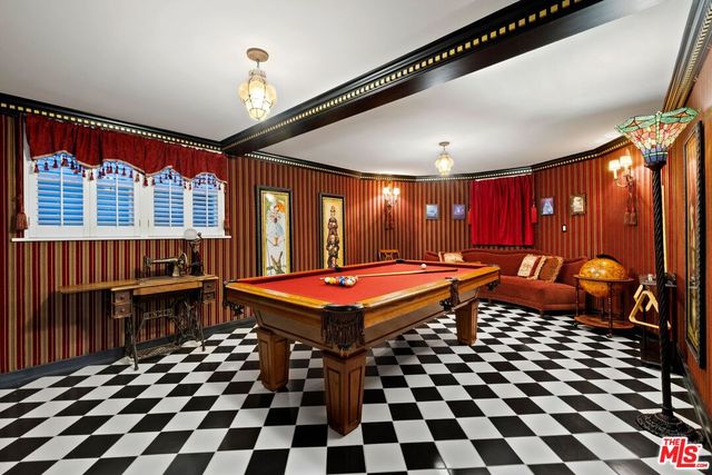 a room with pool table and glass windows
