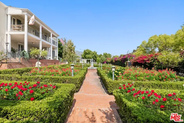a view of flower garden with wooden bridge