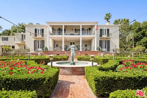 a front view of a house with a yard and fountain